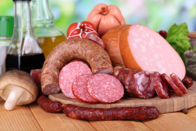 Différentes saucisses sur table en bois sur fond naturel