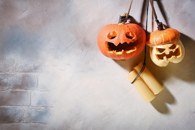 Différentes tailles de citrouilles sur un mur gris clair sculptant une citrouille pour Halloween