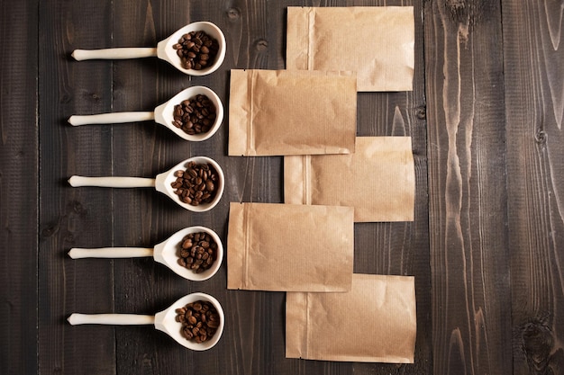 Photo différentes variétés de café naturel torréfié dans des cuillères en bois et des sacs bruns