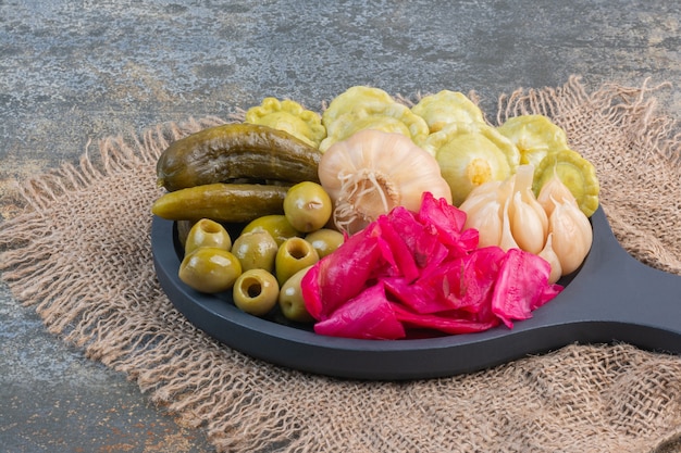 Différents aliments fermentés sur une casserole en bois sur une toile de jute, sur le mixte.