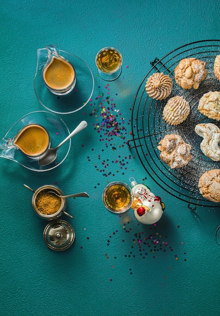 Différents biscuits aux amandes faits maison classiques italiens avec du café expresso et des verres de liqueur douce sur la table, décoration de Noël