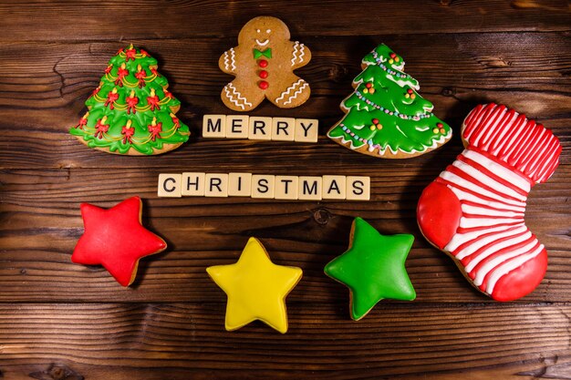 Différents biscuits de pain d'épice de Noël sur une table en bois rustique. Vue de dessus. Inscription joyeux Noël