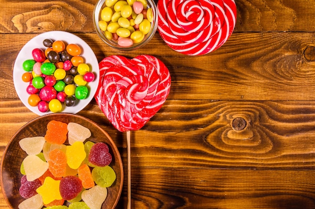 Différents bonbons sucrés sur une table en bois rustique. Vue de dessus