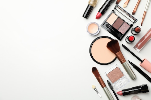 Différents cosmétiques de maquillage sur fond blanc, vue de dessus