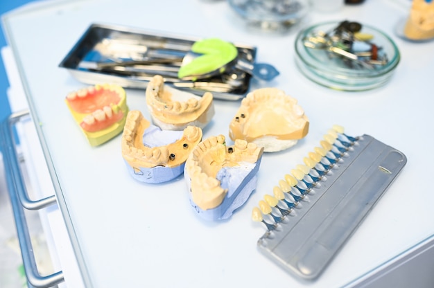 Différents équipements Dentaires Professionnels, Instruments Et Outils Dans Une Clinique De Bureau De Stomatologie De Dentistes Sur Fond Blanc. Moulage En Silicone De La Mâchoire.