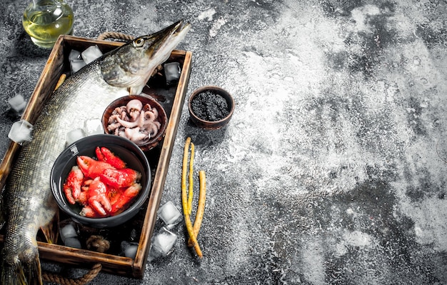 Différents fruits de mer sur un plateau en bois. Sur un fond rustique.