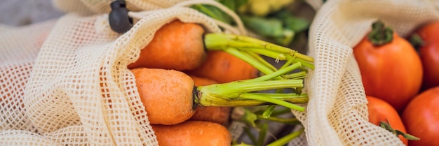 Différents légumes dans des sacs réutilisables sur fond de bois bannière concept zéro déchet format long