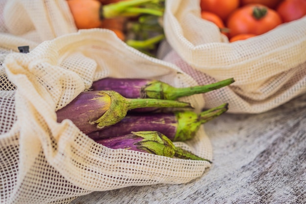 Différents légumes dans des sacs réutilisables sur fond de bois Concept zéro déchet