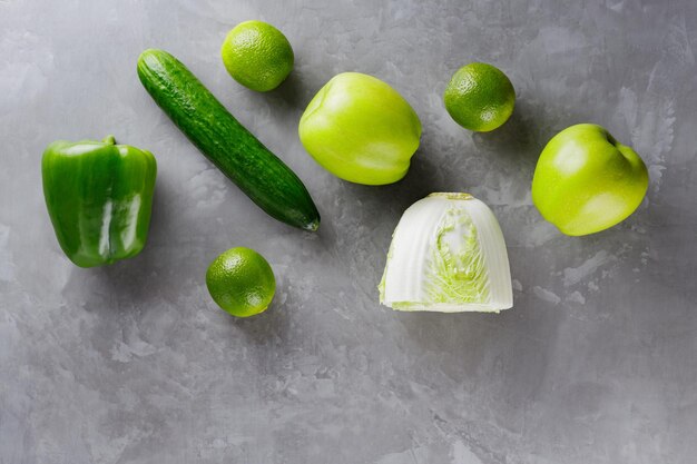 Différents légumes verts et fruits sur fond gris. Concept d'alimentation saine. Vue de dessus. Espace de copie