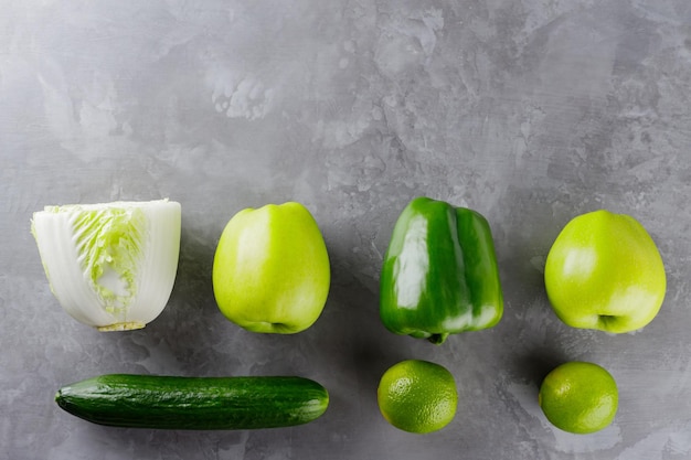 Différents légumes verts et fruits sur fond gris. Concept d'alimentation saine. Vue de dessus. Espace de copie