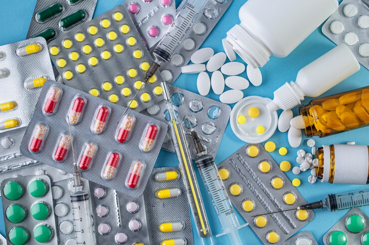 Différents médicaments en comprimés sur fond bleu. Concept de médecine