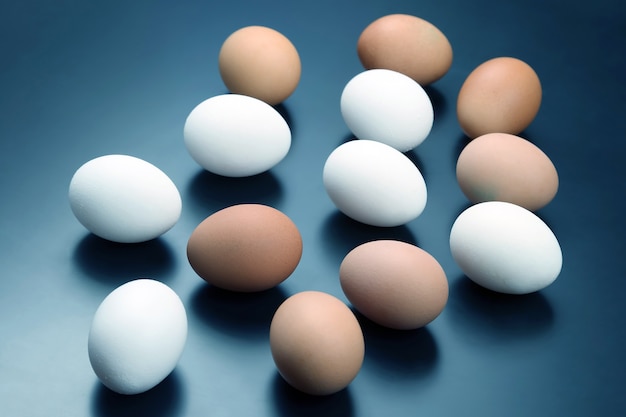 Différents œufs de poule se trouvent sur un fond sombre. Alimentation saine et vitaminée