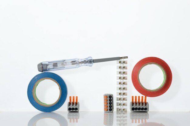 Différents outils pour la réparation de l'électronique disposés sur un fond blanc