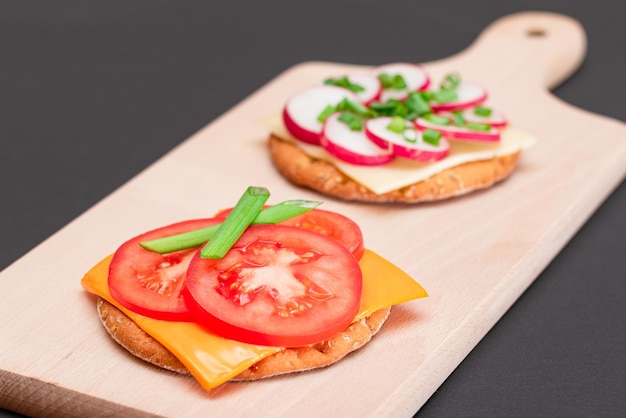 Photo différents sandwichs aux craquelins avec radis de concombre tomate et fromage