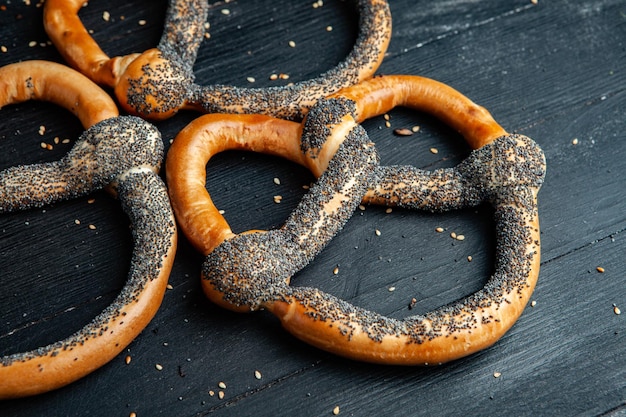 Différents types de bagels cuits au four avec des graines sur fond noir