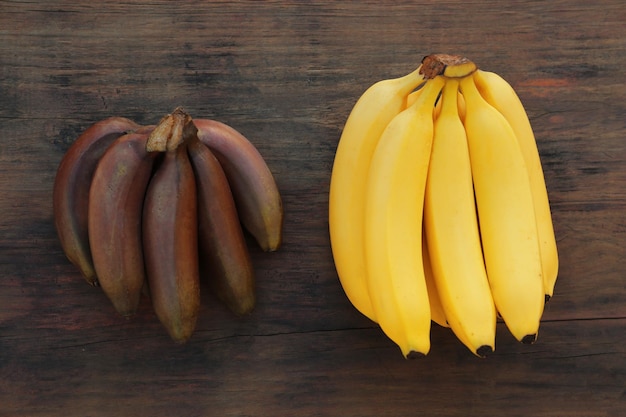 Différents types de bananes sur une table en bois à plat