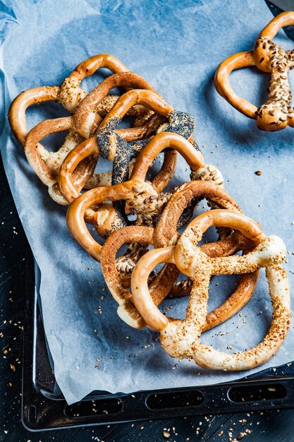 Différents types de bretzels cuits au four ou de bagels avec des graines sur fond noir