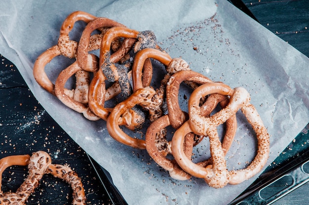 Différents types de bretzels cuits au four ou de bagels avec des graines sur fond noir