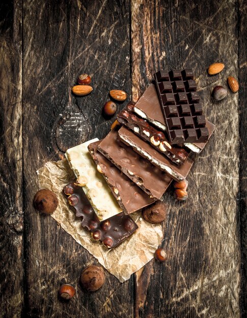 Différents types de chocolat sur table en bois.