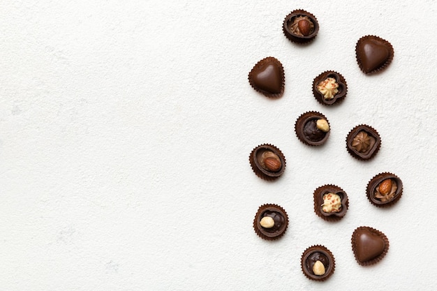 Différents types de chocolats sur une table colorée agrandi Vue de dessus et mise à plat avec espace de copie