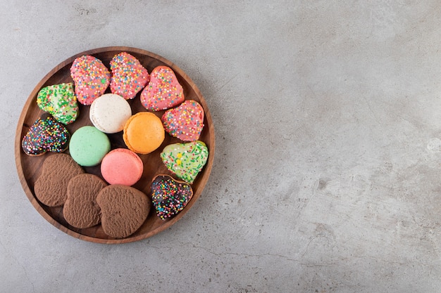 Différents types de cookies sur un plateau en bois sur une surface grise