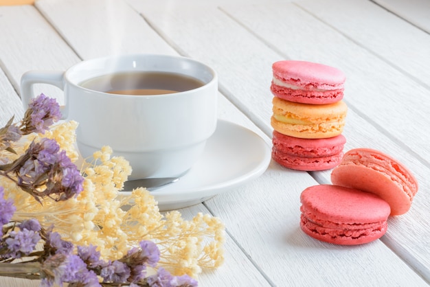 Différents types de couleurs de macarons avec tasse de thé chaud