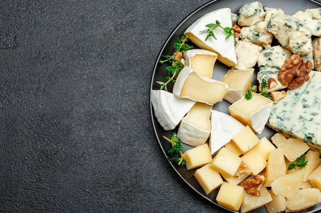 Différents types de fromage en assiette foncée