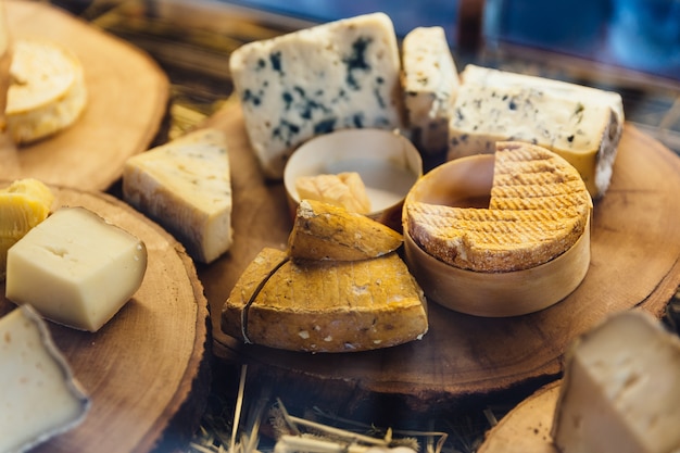 Différents types de fromage sur une planche à découper en bois rustique.