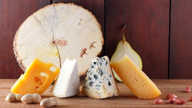 Différents types de fromage poire et arachides sur des planches de bois Camembert fromage jaune dur