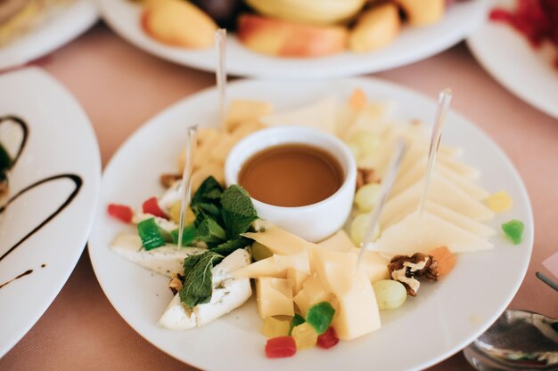 Différents types de fromages sur une assiette et du miel Des collations lors d'une fête de vacances