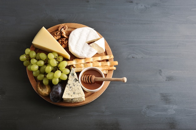 Différents types de fromages avec moisissures, raisins au miel et noix