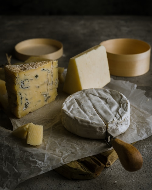 Différents types de fromages à pâte molle et dure sur planche de bois