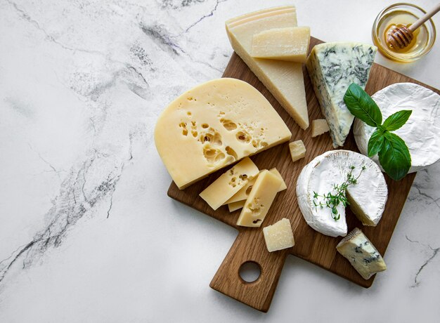 Différents types de fromages, de raisins et de miel sur un fond de marbre