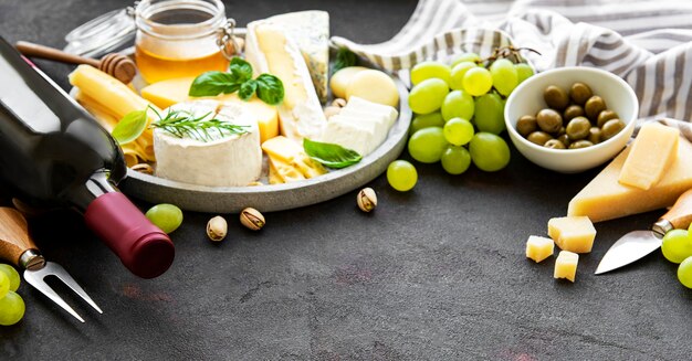 Différents types de fromages, raisins, vins et collations