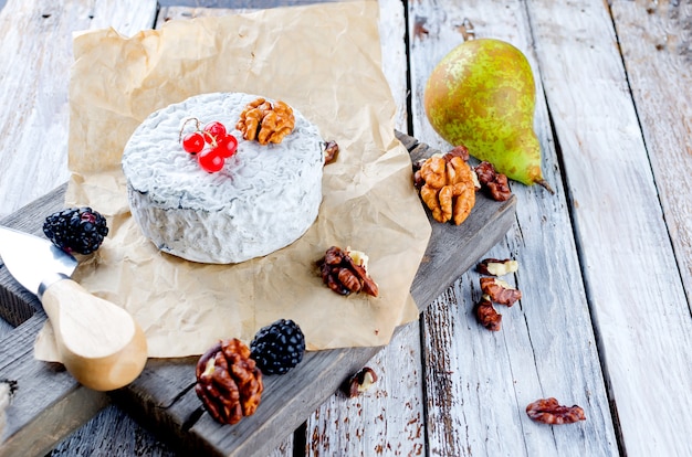 Différents types de fromages sur une vieille table en bois blanc.