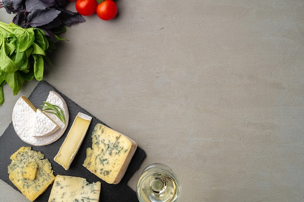 Différents types de fromages et de vins servis sur table grise