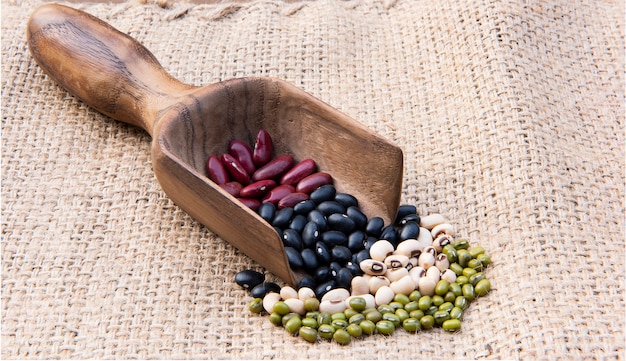 Différents types de grains de céréales sur une cuillère en bois