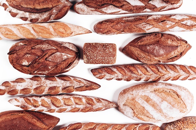Différents types de pain de boulangerie - miches croustillantes rustiques fraîches de pain et de baguette sur fond blanc.