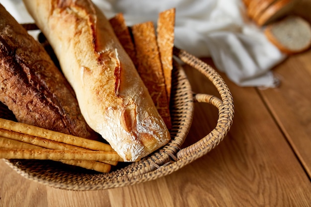 Différents types de pain et de gressins sur une surface en bois