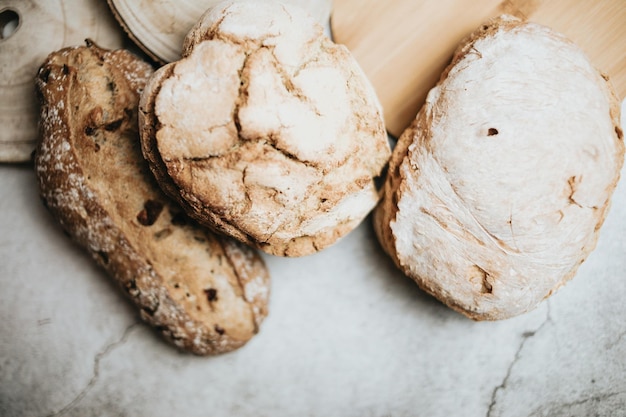 Différents types de pains artisanaux et biologiques fraîchement cuits au four sur une table rustique Cuisine maison Pain au levain avec croûte croustillante sur une étagère en bois Concept de produits de boulangerie Restaurant et produits