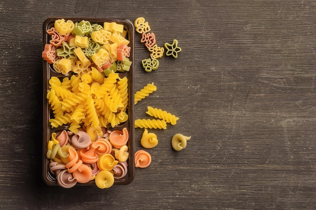 Différents types de pâtes crues dans une boîte sur la table