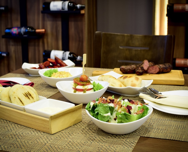 différents types de salades avec du bois et des bouteilles de vin