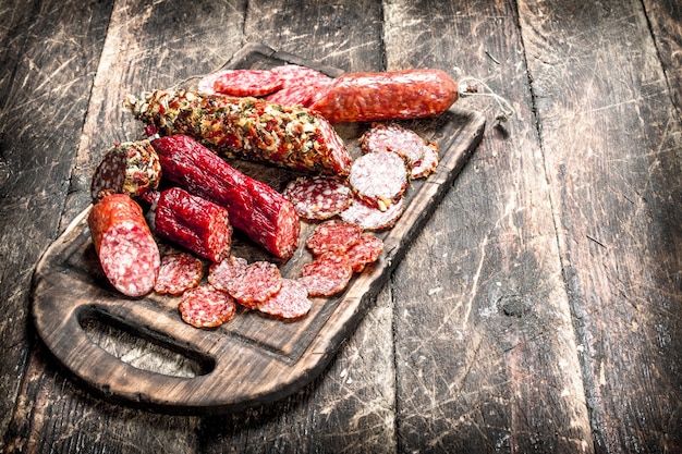 Différents types de salami sur les planches. Sur une table en bois.