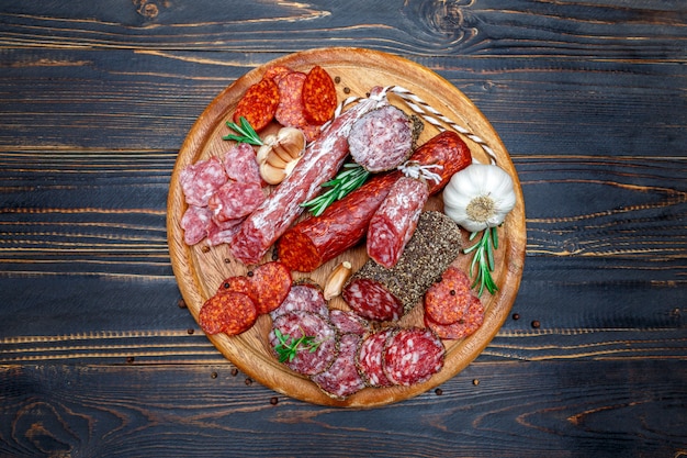 Différents types de saucisses salami bio séchées sur une planche à découper en bois