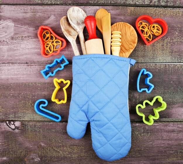 Photo différents ustensiles de cuisine dans un porte-pot sur fond de bois