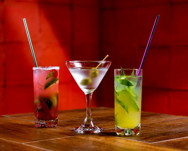 différents verres de cocktail sur un bar en bois