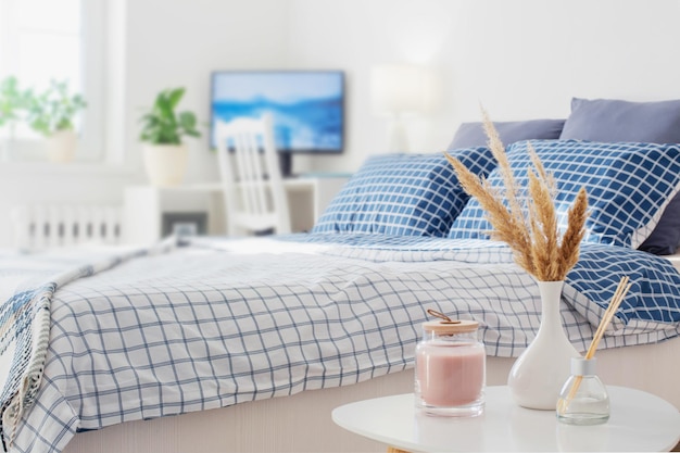 Diffuseur et bouquet de plantes séchées dans un vase dans la chambre au soleil