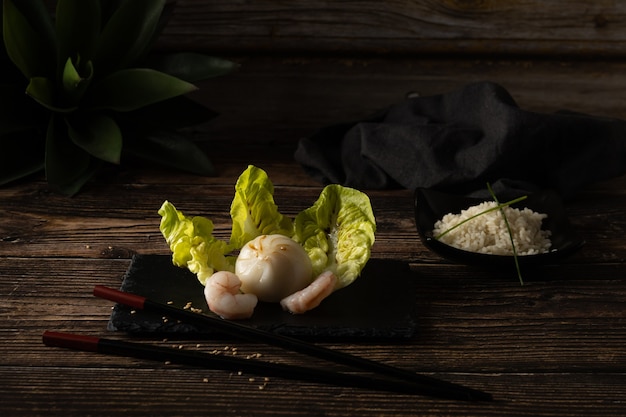 Dim sum de porc et de crevettes cuits à la vapeur sur la pierre d'ardoise sur la table en bois