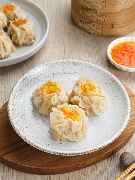 Dimsum de boulette cuit à la vapeur servi dans une assiette avec sauce chili