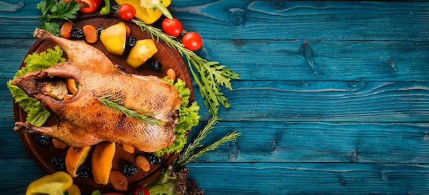 Dinde au four avec des légumes et des épices Jour de Thanksgiving Grillade de poulet d'oie Sur un fond en bois Vue de dessus